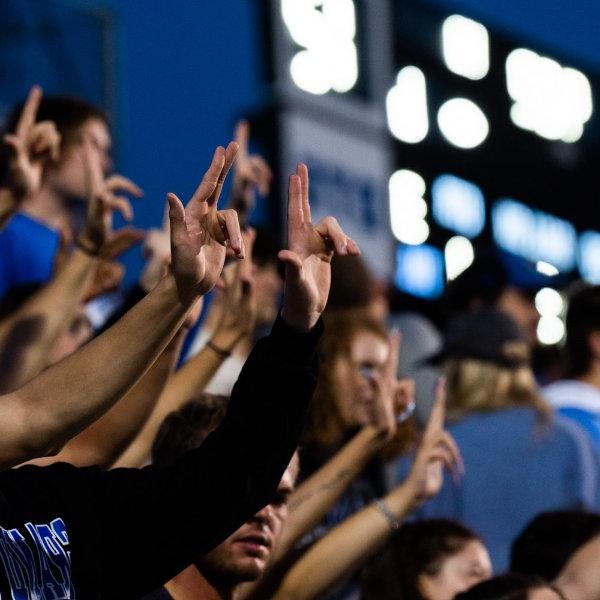 在一场橄榄球比赛中，GVSU的学生高举双手在湖人队.